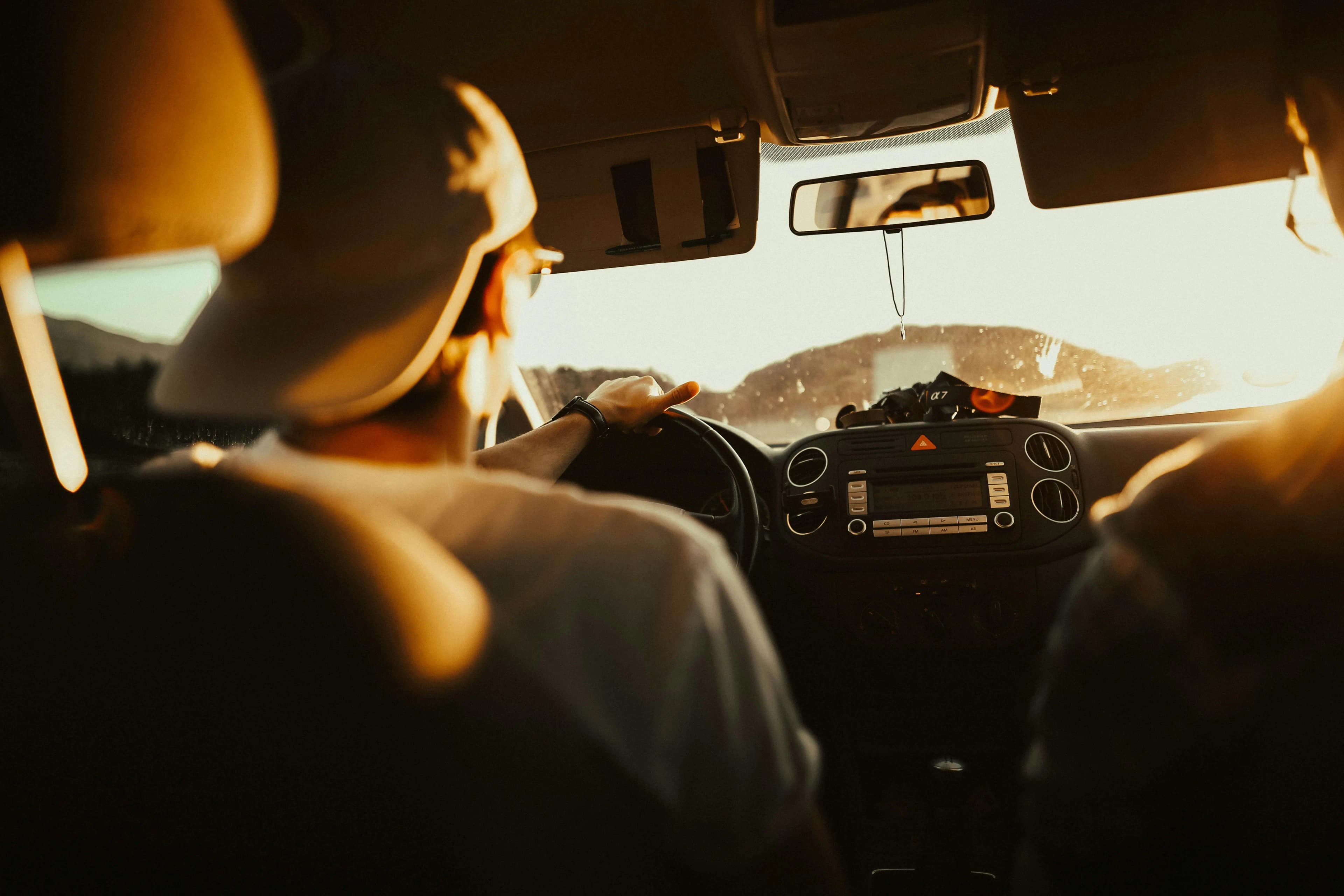 A luxury rental car driving on a scenic road, symbolizing the freedom of skipping the rental counter.